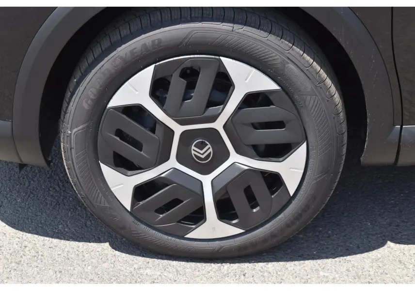 Gros plan sur la roue avant droite noire d'une Citroën C4 Hybride 2025 avec enjoliveur 18 pouces AEROTECH bicolore.