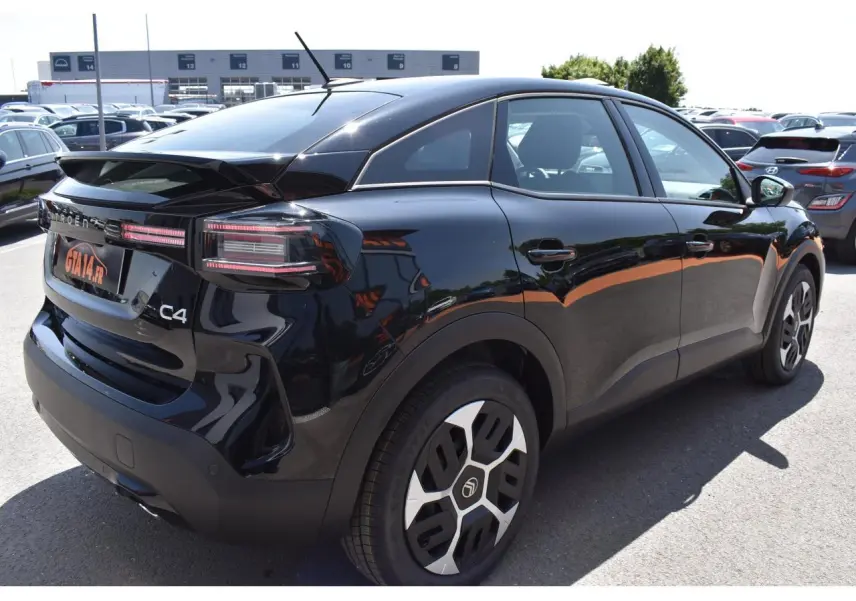 Vue 3/4 arrière droite d'une Citroën C4 Hybride noire 2025 avec feux LED et jantes Aerotech 18 pouces.