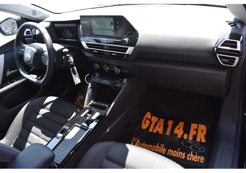 Vue intérieure côté conducteur de la Citroën C4 Hybride 2025 avec tableau de bord noir et écran tactile central 10 pouces.