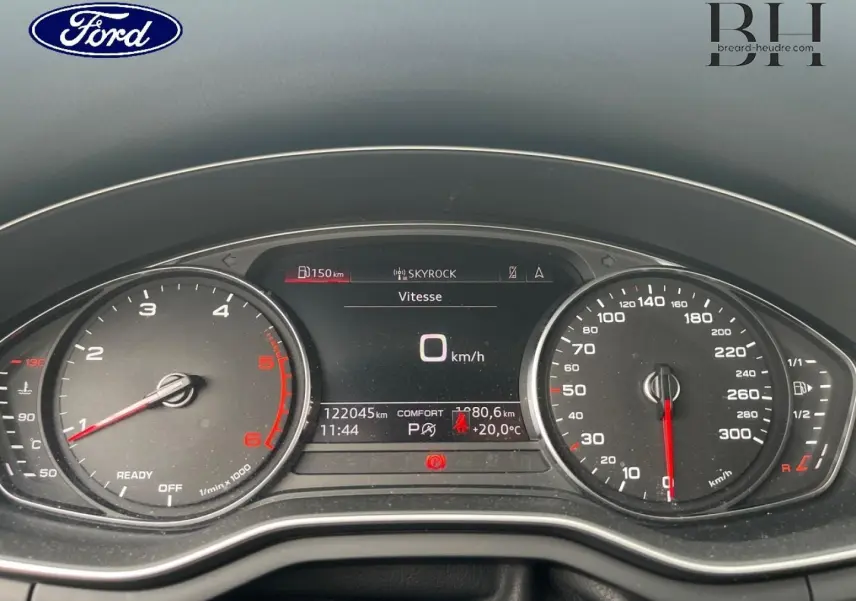 Vue rapprochée du tableau de bord numérique d'une Audi A4 Avant blanc glacier, affichant la vitesse à 0 km/h.