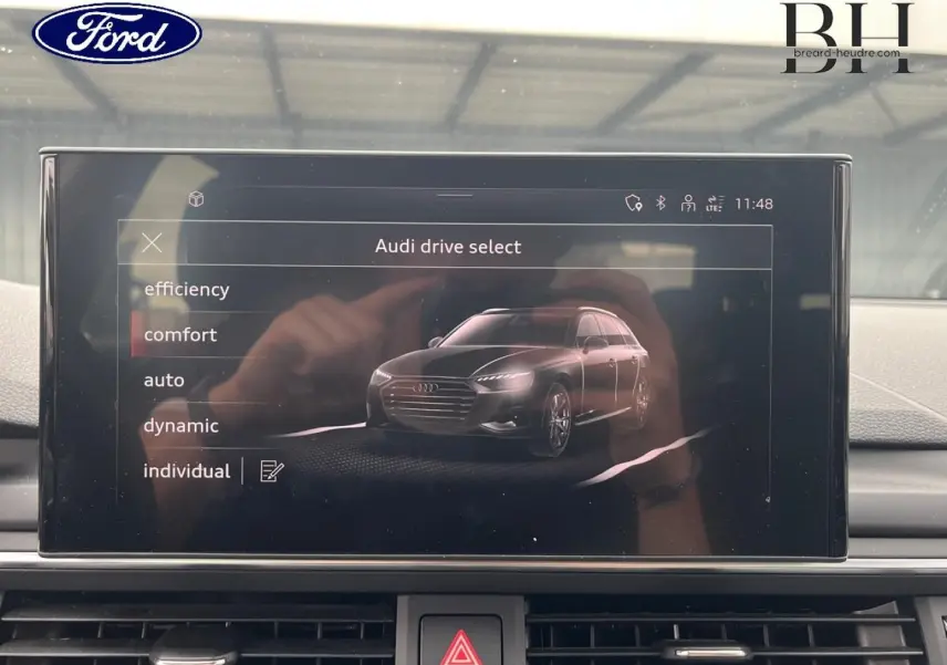 Écran central intérieur montrant le menu Audi drive select avec une illustration 3D d'une Audi A4 Avant.