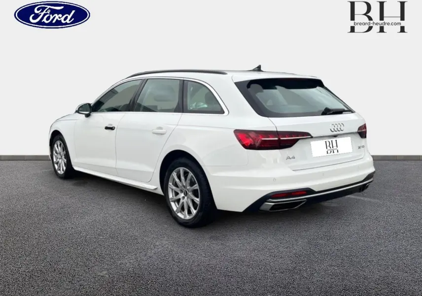 Audi A4 Avant blanc glacier métallisé vue 3/4 arrière droit, avec jantes alu et feux arrière LED distinctifs.