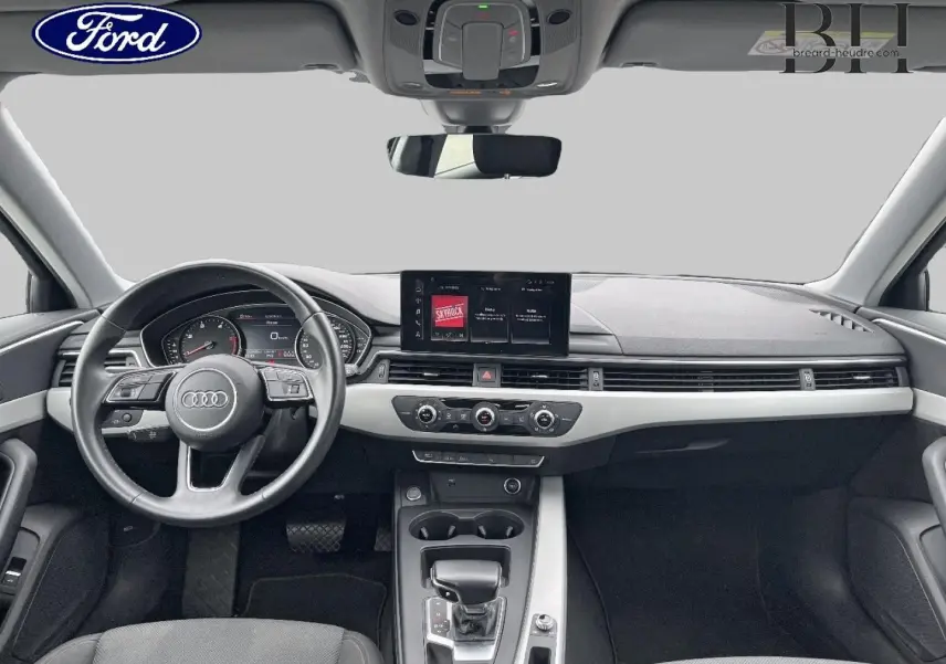 Vue intérieure avant de l'Audi A4 Avant 30 TDI 2021, tableau de bord noir avec écran central et volant cuir multifonction.