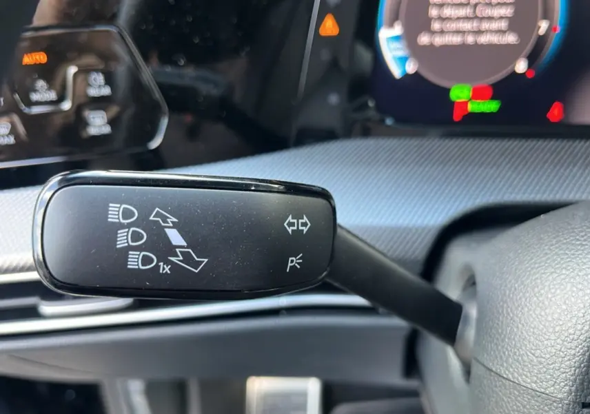 Gros plan sur la commande de clignotants à gauche du volant dans l’habitacle d’une Volkswagen Golf noir ébène 2026.