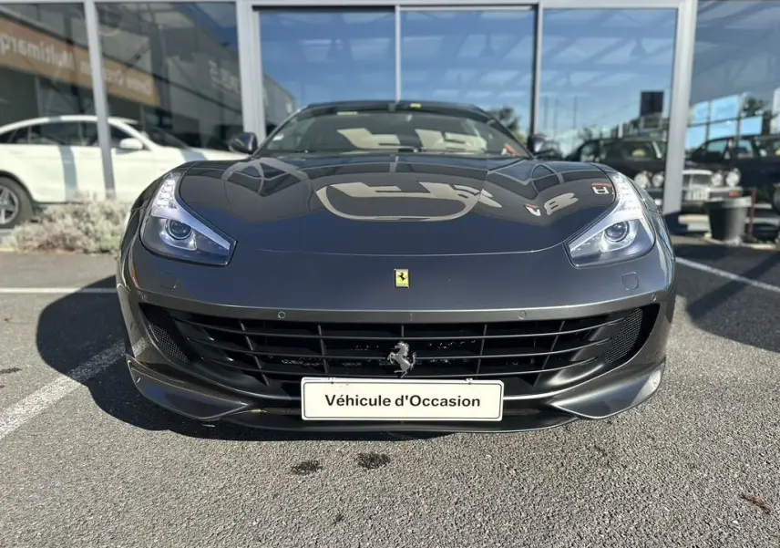 Vue frontale d'une Ferrari GTC4 Lusso gris foncé 2017 avec calandre noire et logo cheval cabré au centre.