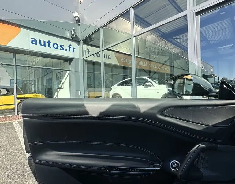 Vue intérieure de la porte côté gauche en cuir noir de la Ferrari GTC4 Lusso gris foncé 2017 stationnée en extérieur.