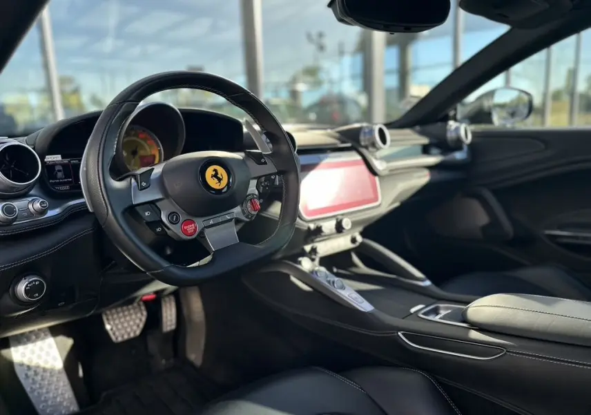 Intérieur de la Ferrari GTC4 Lusso 2017 en gris foncé, vue côté conducteur sur le volant avec logo cheval cabré.