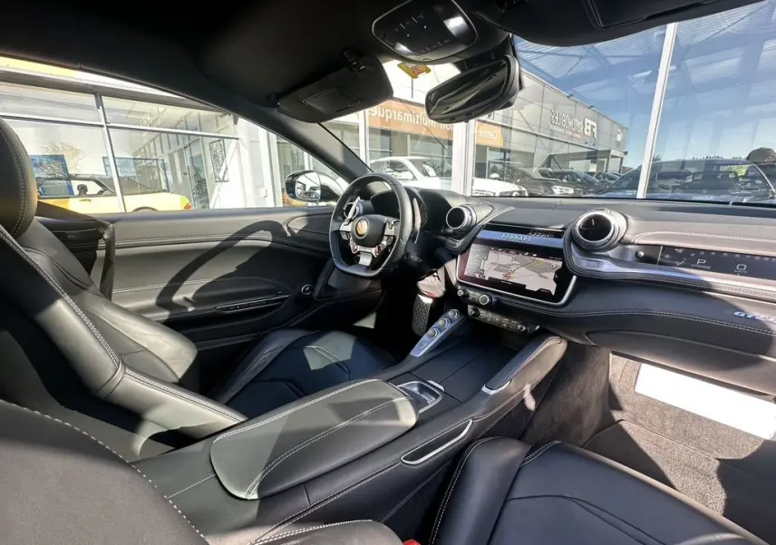 Intérieur noir cuir de la Ferrari GTC4 Lusso 2017 vu côté conducteur, avec tableau de bord et écran tactile.