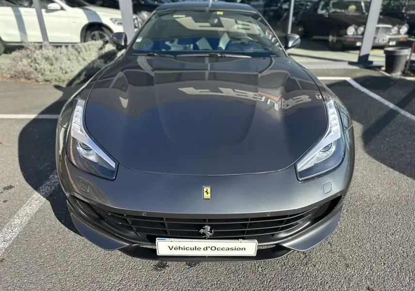 Vue avant plongeante d'une Ferrari GTC4 Lusso gris foncé avec ses phares LED distinctifs et calandre noire.