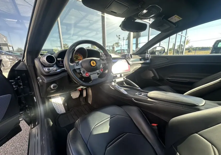 Intérieur noir de la Ferrari GTC4 Lusso 2017 vu côté conducteur, avec volant sport et tableau de bord moderne.