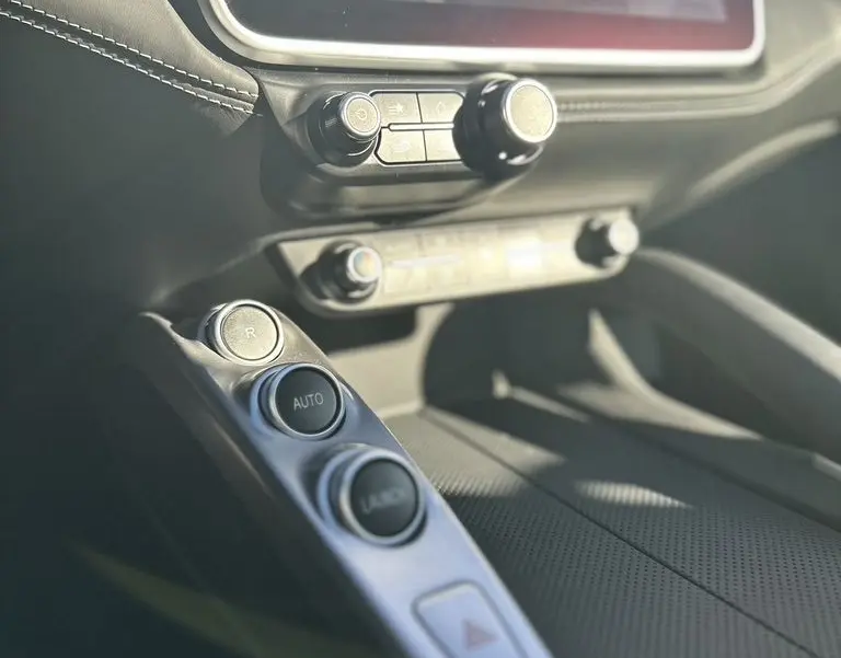 Détail de la console centrale de la Ferrari GTC4 Lusso gris foncé de 2017, avec commandes de boîte automatique et écran tactile.
