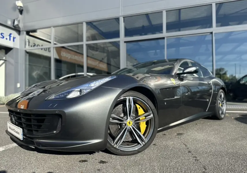Ferrari GTC4 Lusso gris foncé vue 3/4 avant avec jantes alliage et étriers de frein jaunes visibles.