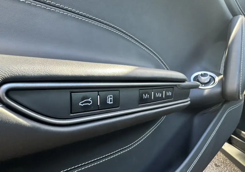 Gros plan sur la porte côté gauche de la Ferrari GTC4 Lusso 2017, cuir gris foncé avec boutons de réglages mémoire M1, M2, M3.