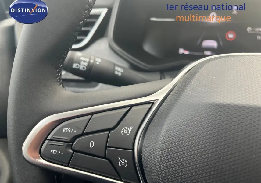 Gros plan sur le volant côté gauche de la Renault Clio 2024, montrant les commandes de régulateur de vitesse.