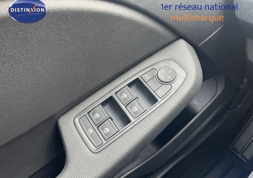 Gros plan sur les commandes de lève-vitres et rétroviseurs côté conducteur de la Renault Clio gris schiste 2024.