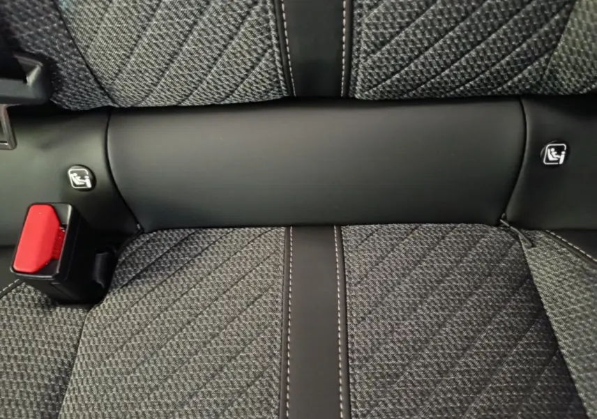 Gros plan sur la banquette arrière gris foncé avec coutures contrastées et ceintures de sécurité rouges de la Peugeot 208 2025.