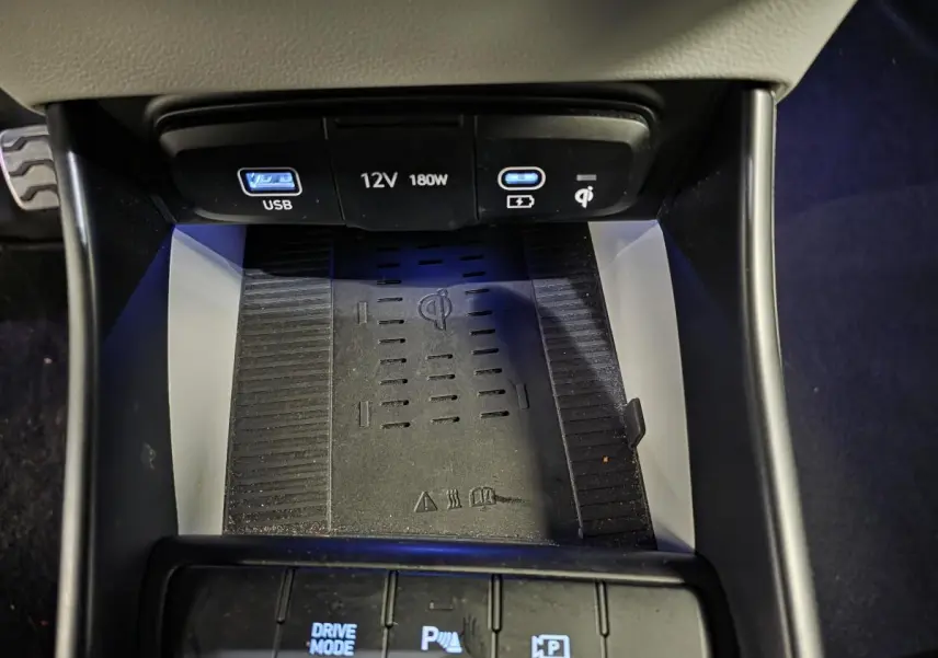 Gros plan sur la console centrale du Hyundai Bayon 2025 noire, montrant la recharge sans fil et ports USB éclairés.