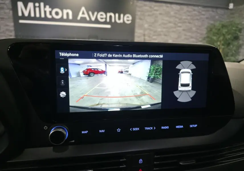 Écran tactile intérieur montrant la caméra de recul du Hyundai Bayon noir avec aides au stationnement activées.