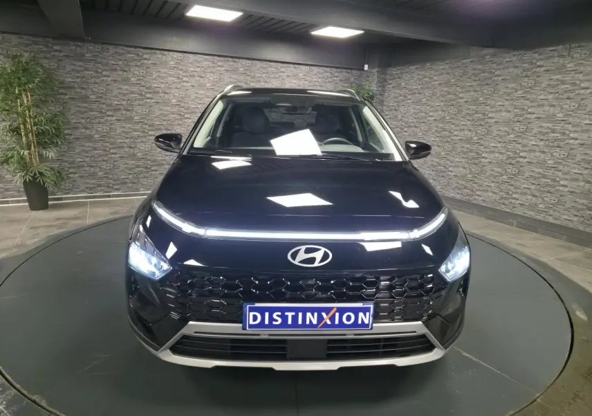 Vue frontale d'un Hyundai Bayon noir métallisé 2025 avec calandre noire laquée et feux LED allumés.