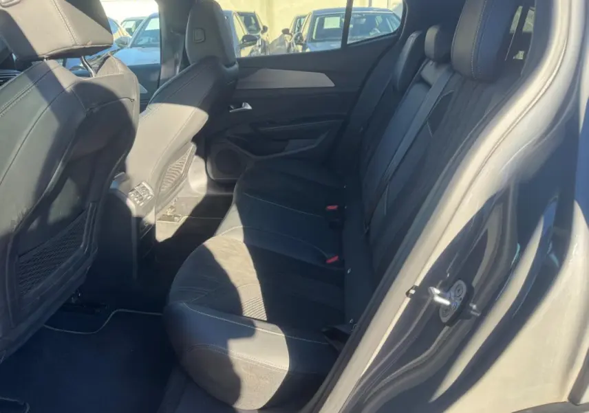Vue côté droit de l'habitacle arrière gris du Peugeot 408 Hybrid 136 e-DCS6 GT avec sièges en tissu et cuir.