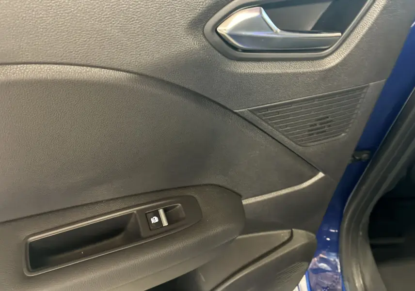 Détail de la porte avant droite intérieure noire avec bouton de commande de vitre, sur Renault Captur bleu 2021.