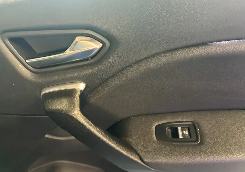 Détail de la poignée intérieure et commande de lève-vitre sur la porte côté droit du Renault Captur bleu 2021.