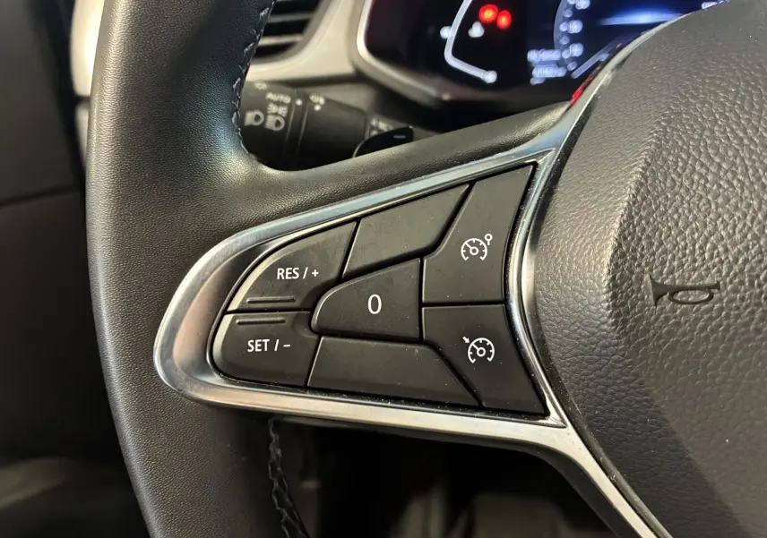 Gros plan sur les commandes de régulateur de vitesse au volant noir du Renault Captur 2021, version Intens.