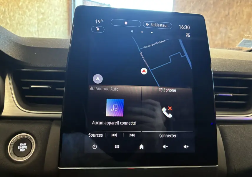 Écran tactile central du tableau de bord du Renault Captur bleu 2021, affichant la navigation et les options multimédia.