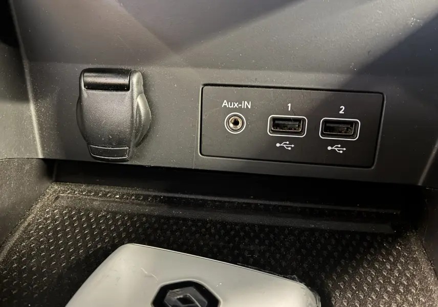 Prise auxiliaire et deux ports USB visibles dans l'habitacle du Renault Captur bleu 1.3 TCE 140 Intens, vue rapprochée.