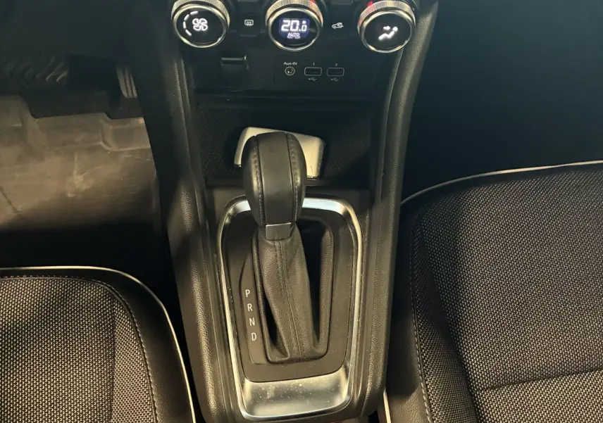 Vue plongeante sur la console centrale du Renault Captur bleu 2021, montrant la boîte auto et les commandes de climatisation.