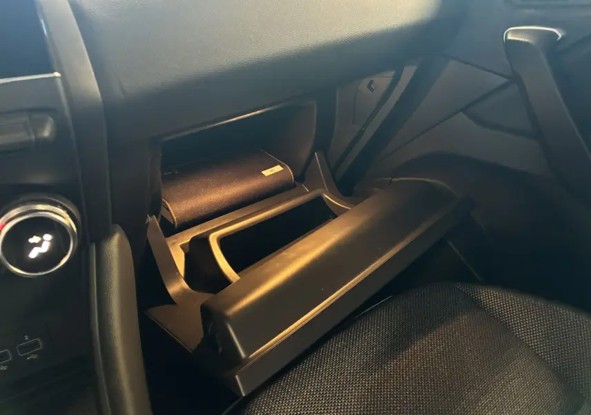 Vue intérieure côté passager du Renault Captur 1.3 TCE 140 Intens 2021, boîte auto, montrant la boîte à gants ouverte avec un livret à l'intérieur.