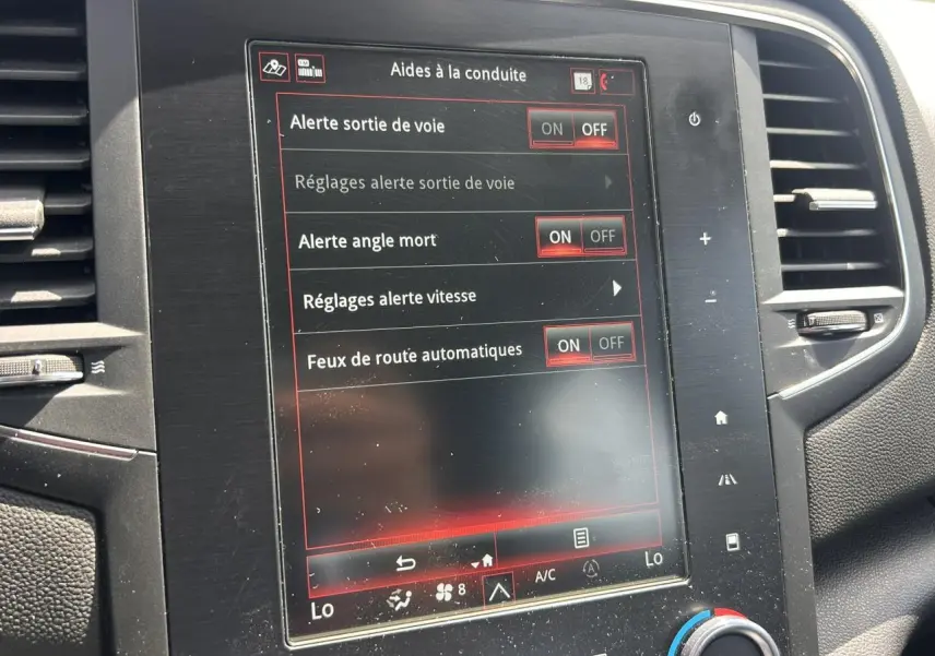 Écran tactile central de la Renault Mégane IV Intens 2020 affichant les aides à la conduite activées.