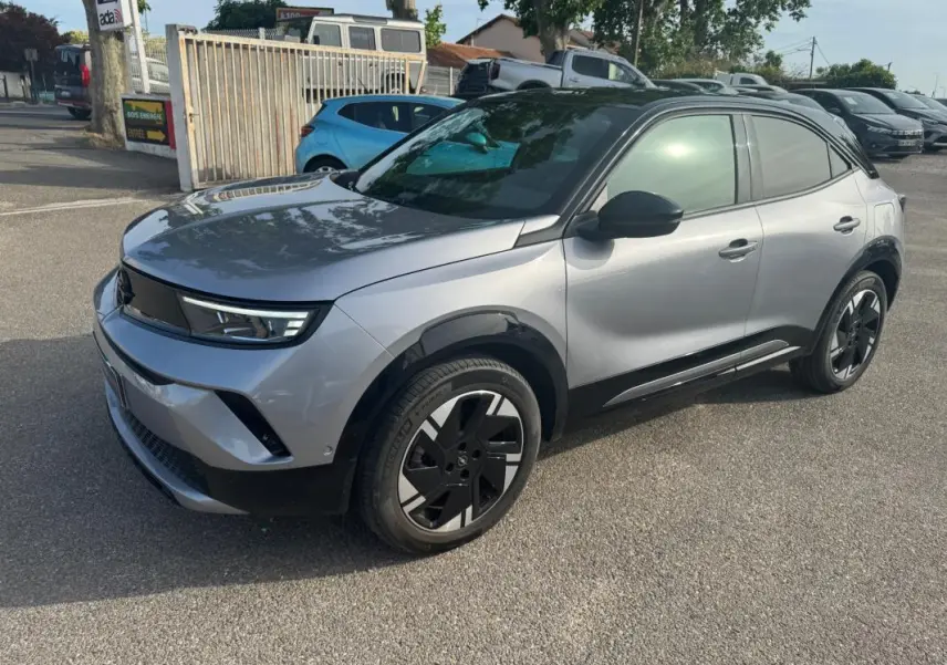 Opel Mokka électrique gris vue 3/4 avant droit, jantes alliage 17 pouces et vitres surteintées visibles.