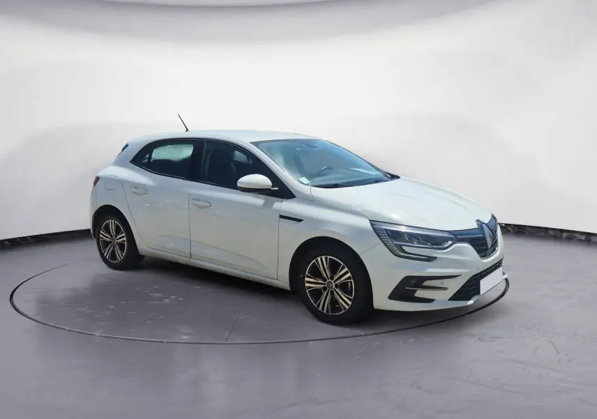 Renault Mégane 1.5 Blue dCi 115 Evolution blanche vue 3/4 avant droit sur parking ensoleillé.