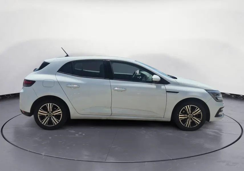 Profil côté gauche d'une Renault Mégane blanche 2022 avec jantes alliage et lignes épurées sur un parking extérieur.