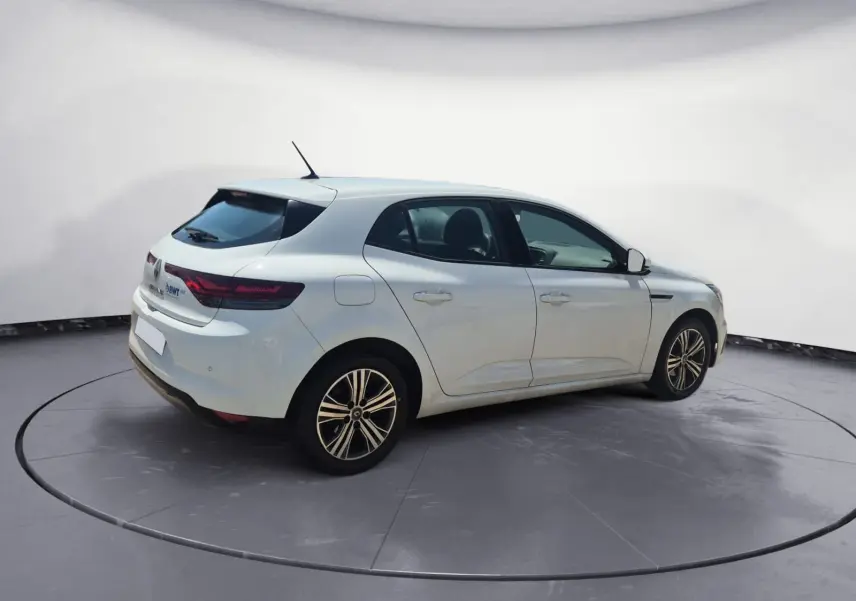 Renault Mégane blanche vue 3/4 arrière droit sur parking, avec feux arrière LED et jantes alliage 16 pouces.