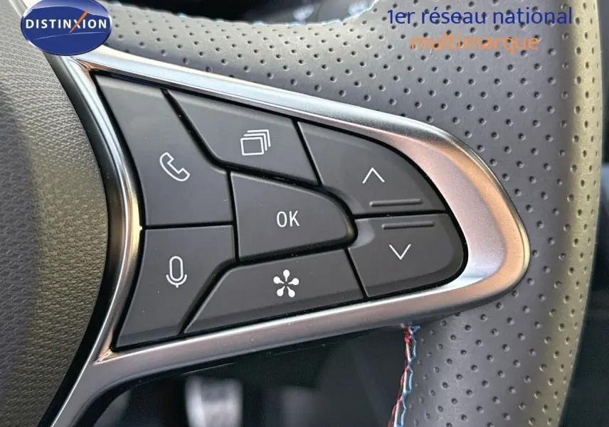 Gros plan sur les commandes multifonctions du volant perforé du Renault Symbioz gris Cassiope, version E-Tech 145 Esprit Alpine.