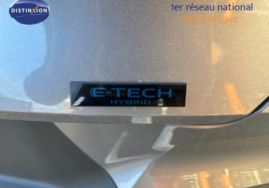 Gros plan sur l'emblème E-TECH Hybrid sur la partie arrière grise cassiope du Renault Symbioz 2024.