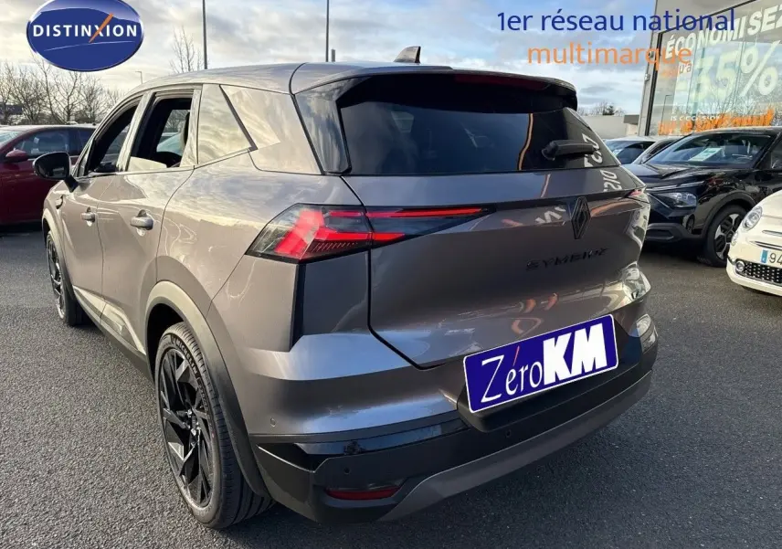 Vue 3/4 arrière du Renault SYMBIOZ gris Cassiope avec hayon fermé et jantes noires distinctives.