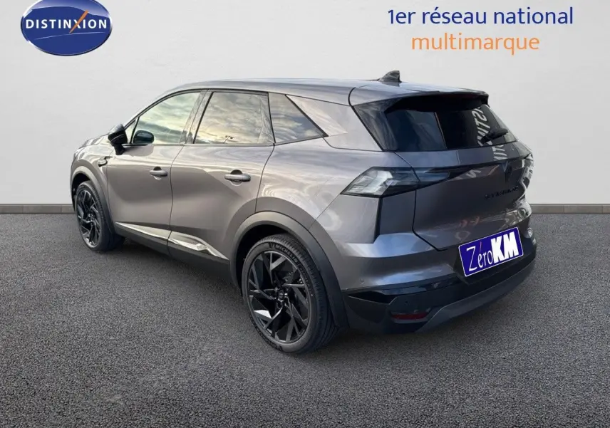 Vue 3/4 arrière droite du Renault SYMBIOZ 2024 gris Cassiope avec jantes noires et hayon électrique visible.