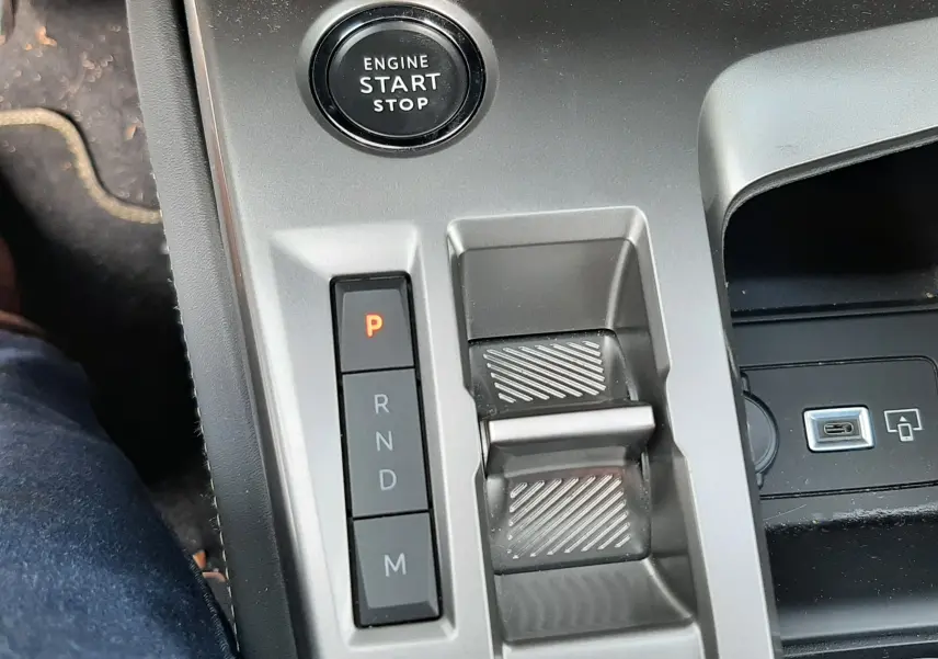 Gros plan sur la console centrale de la Peugeot 308 SW blanche, montrant le bouton start/stop et la commande de boîte auto.