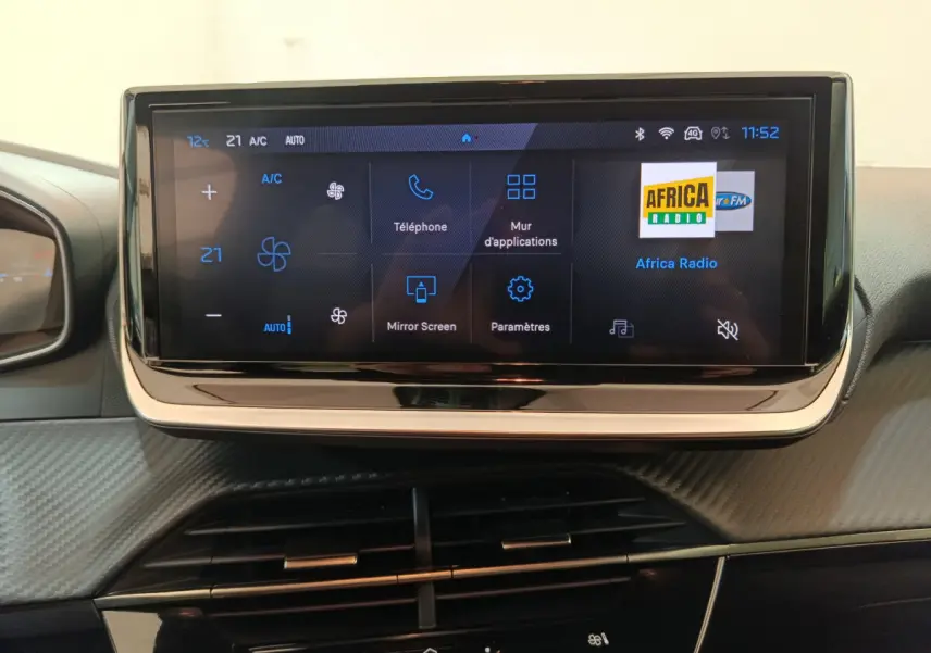 Écran tactile central de 10 pouces affichant le menu multimédia dans l'habitacle d'une Peugeot 208 gris clair.