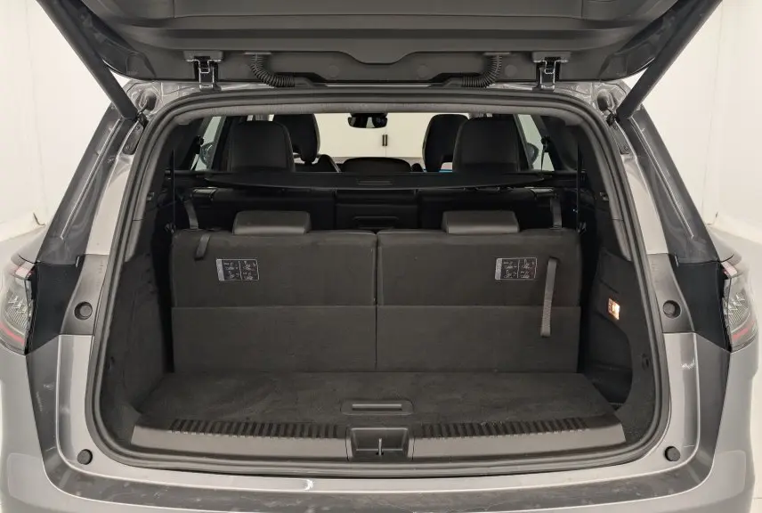 Coffre ouvert vu de l'arrière d'un Renault Espace 2025 gris schiste, montrant la banquette arrière et l'espace de chargement.