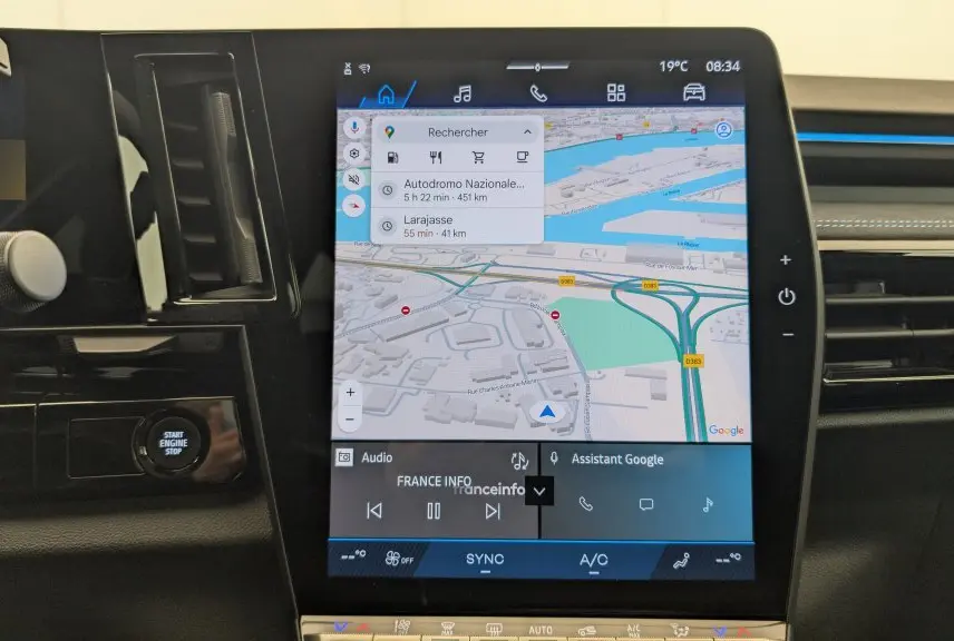 Écran tactile central du tableau de bord du Renault Espace gris, affichant la navigation Google Maps et commandes multimédia.
