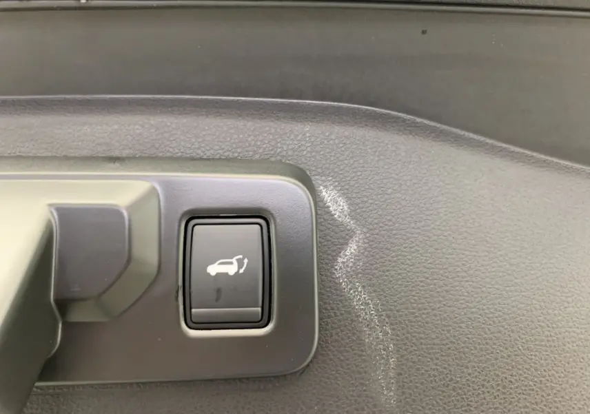 Bouton d'ouverture du hayon motorisé sur panneau intérieur noir du Renault Espace E-Tech hybride 2025.