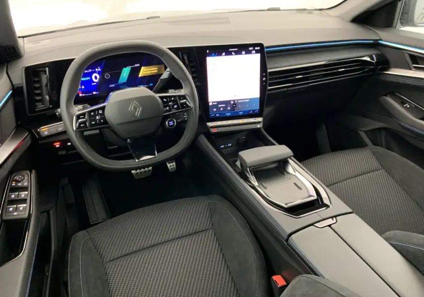 Vue intérieure avant du Renault Espace 2025 E-Tech gris, avec tableau de bord numérique et écran tactile vertical lumineux.