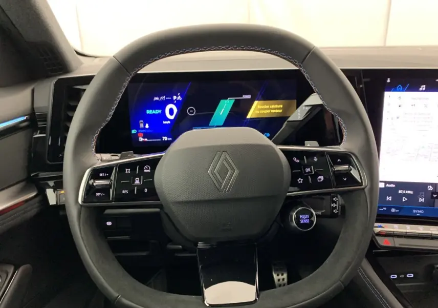 Vue rapprochée du volant noir avec surpiqûres bleues et tableau de bord numérique du Renault Espace E-Tech Gris Schiste.