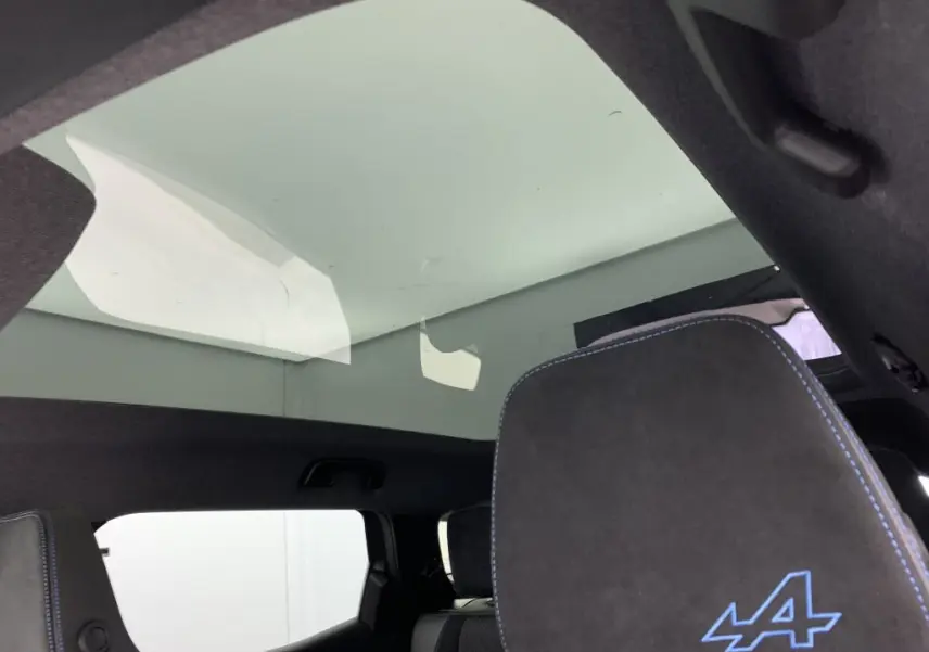 Toit panoramique en verre et appuie-tête avant gris anthracite avec logo Alpine bleu dans un Renault Espace 2025.