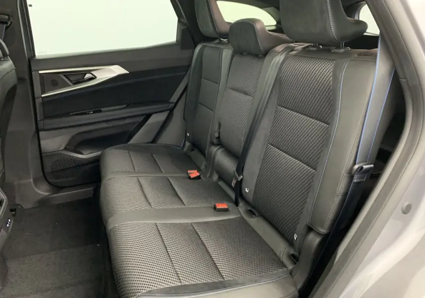 Banquette arrière en sellerie mixte tissu carbone et alcantara noire avec surpiqûres bleues dans Renault Espace 2025 côté droit.
