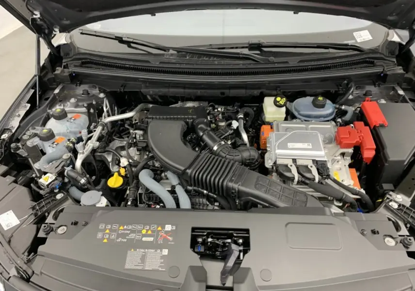 Moteur hybride visible sous le capot ouvert d'un Renault Espace 2025 gris schiste, vue de face détaillée.